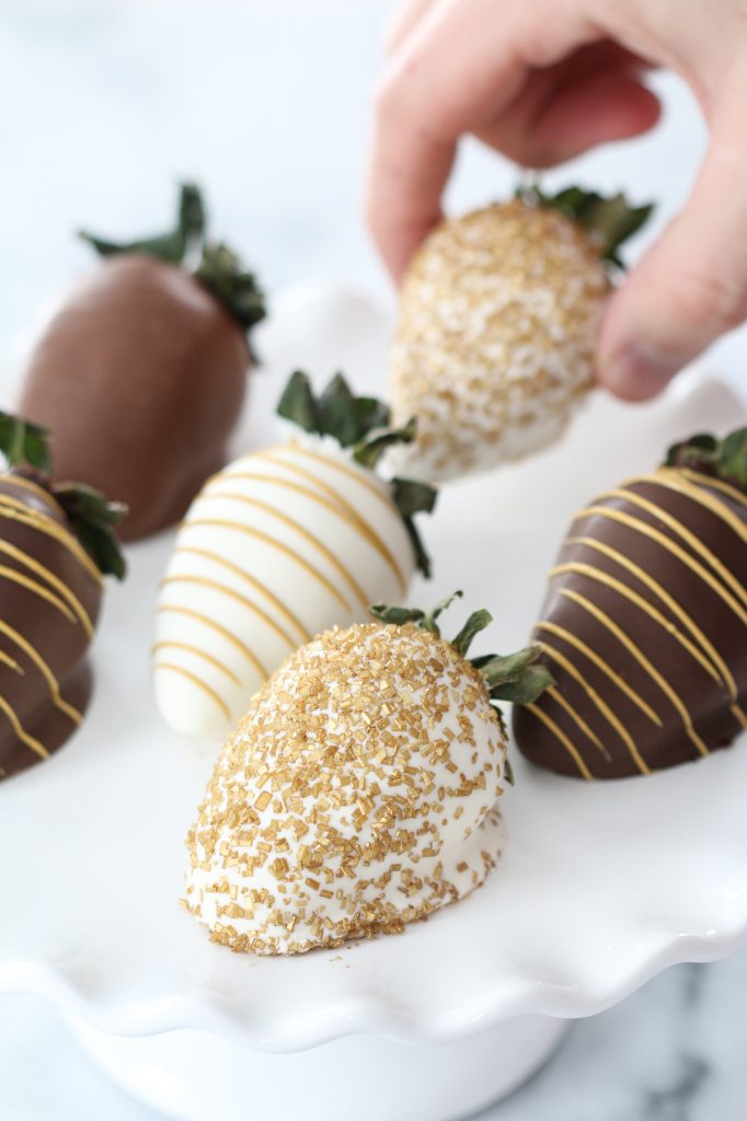 hand taking chocolate covered strawberries