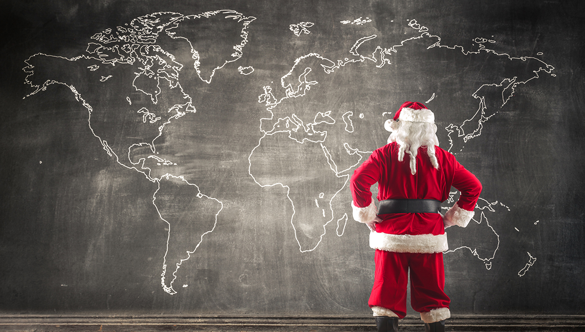 Santa Claus looking at a map of the world.
