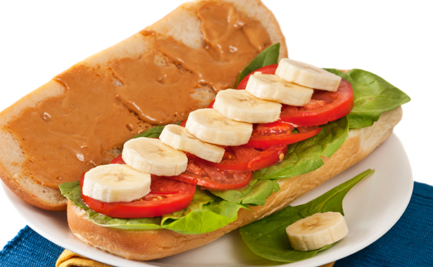 Vegetarian peanut butter and banana submarine sandwich on white bun, ready to eat.