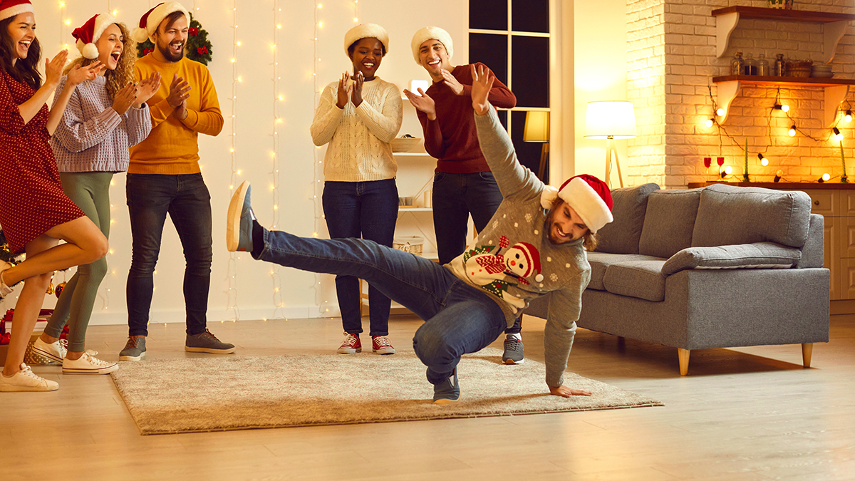 ugly sweater party with a man breakdancing wearing a Santa hat.
