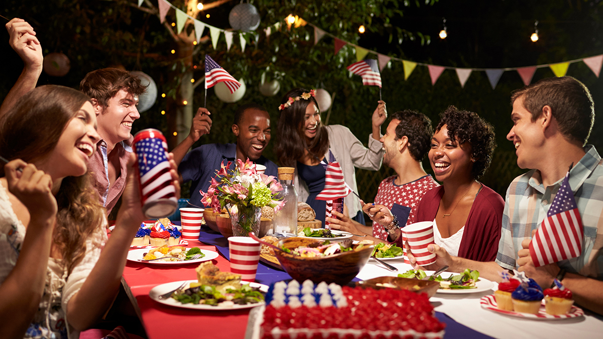 fourth of july facts with people celebrating around a table of food