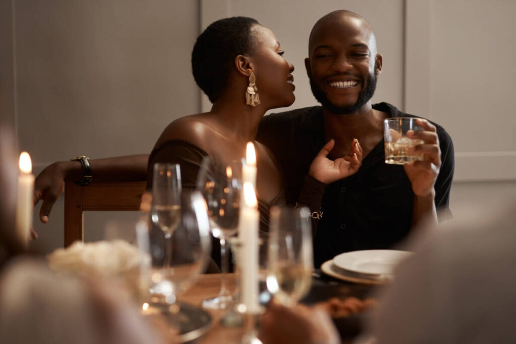 Love, happy or black couple in restaurant, party or dinner celebration bonding for New years, birthday or anniversary date. Drink, smile or black woman and man for success, toast or alcohol at night