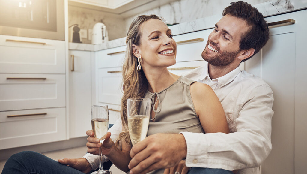 anniversary date ideas with a couple with champagne in kitchen