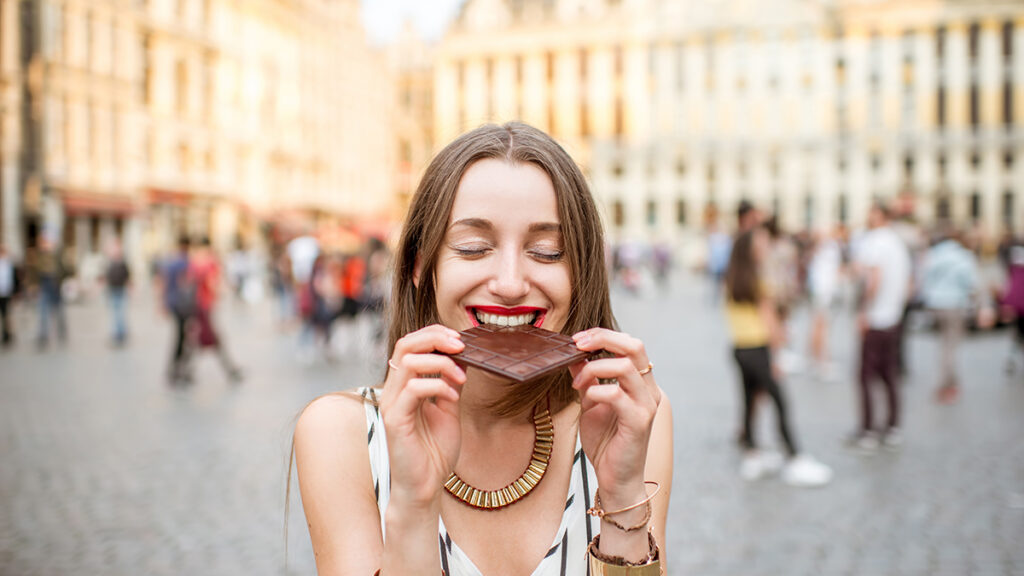 belgian chocolate being eaten by a woman in a public square